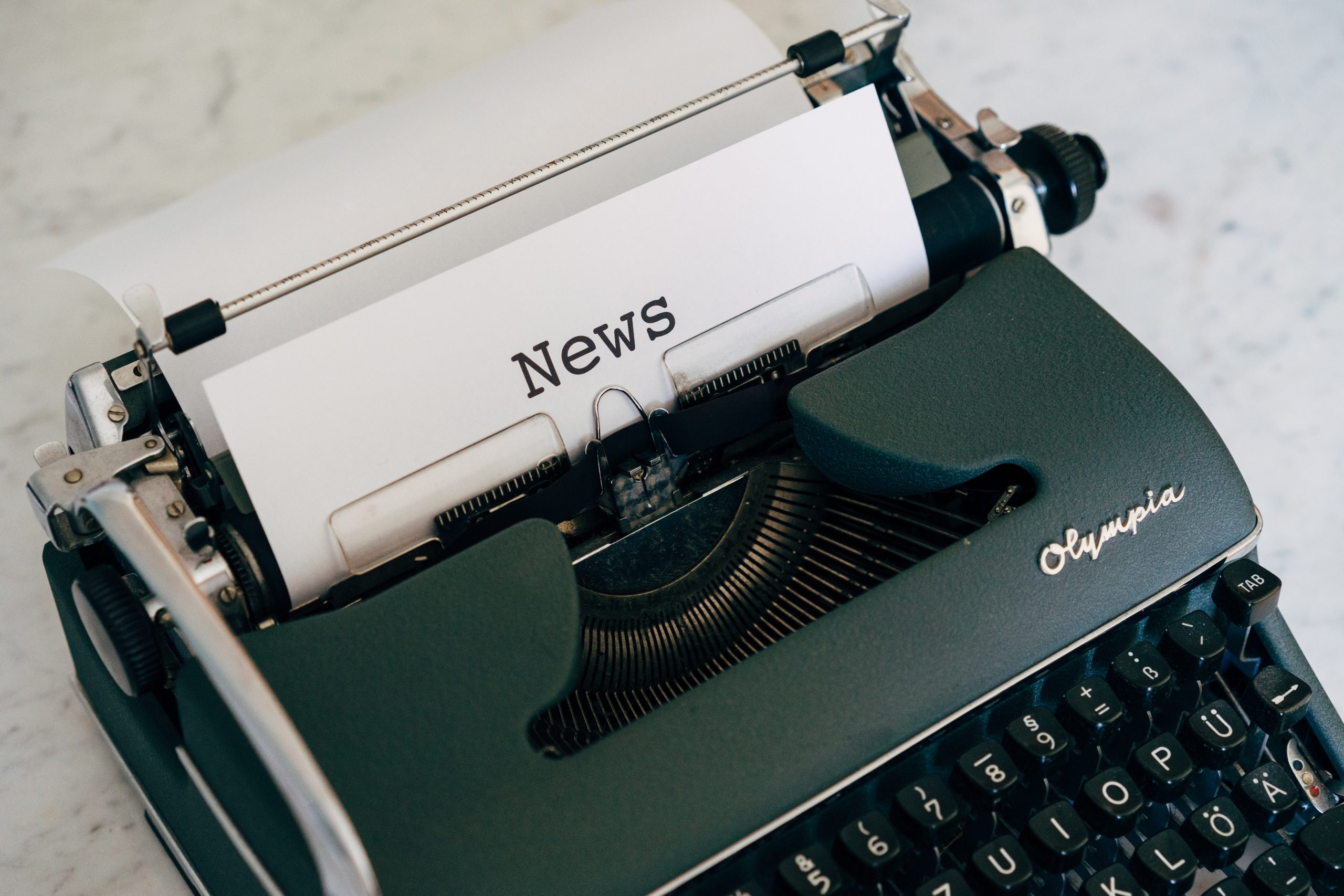 máquina de escribir y papel que dice news